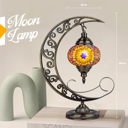 Decorative moon-shaped lamp with mosaic design on a light background